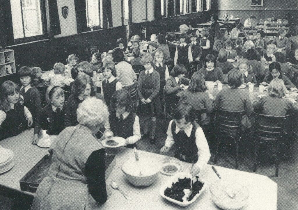 Black and white photo of children in a dining room at Ockbrook School
