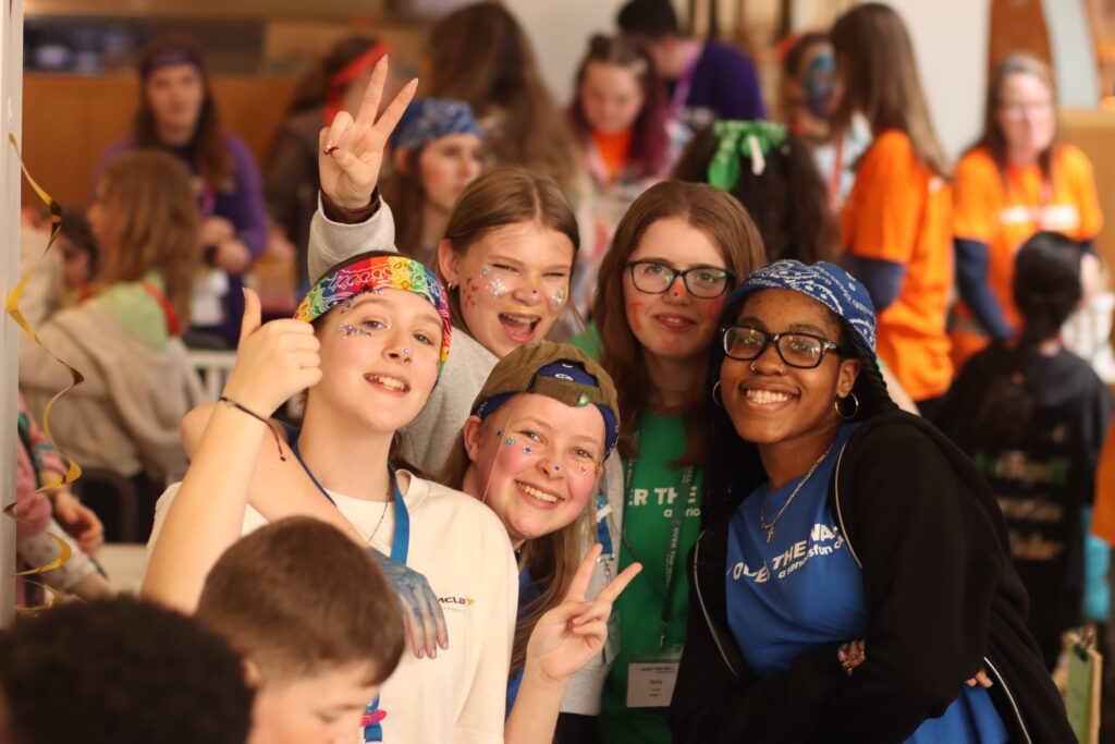 Large group of children smiling in Over The Wall Camp t-shirts
