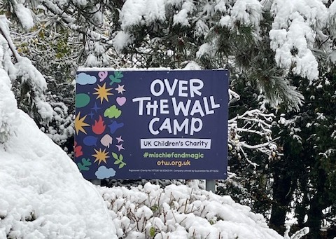 Over The Wall Camp sign in a snowy backdrop